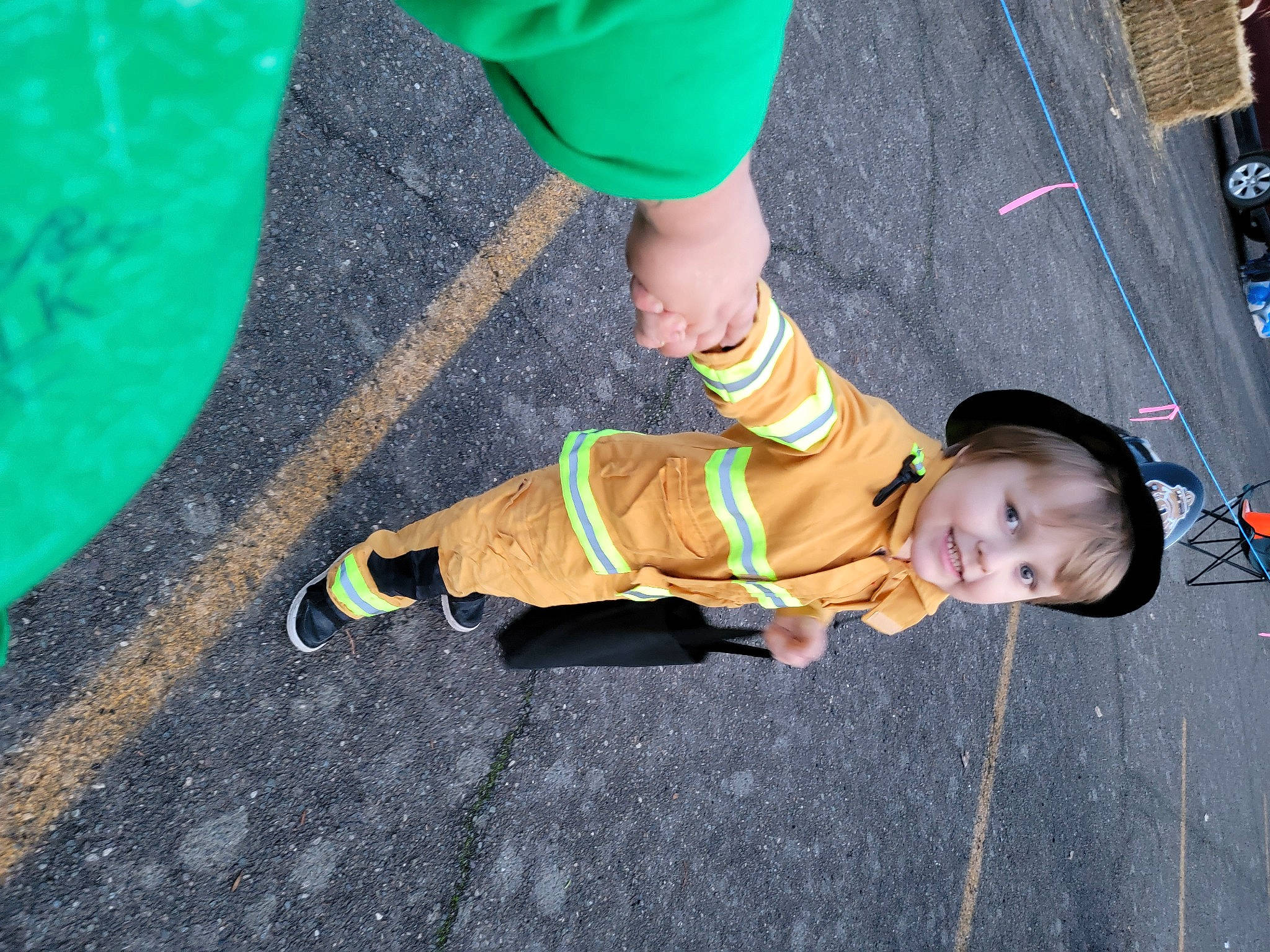 Jayden is registered to the contest to win money with this photo: asphalt, child, costume, electric_blue, event, flooring, fun, grass, green, hat, human_leg, joy, knee, leg, leisure, person, play, sidewalk, sneakers, sock