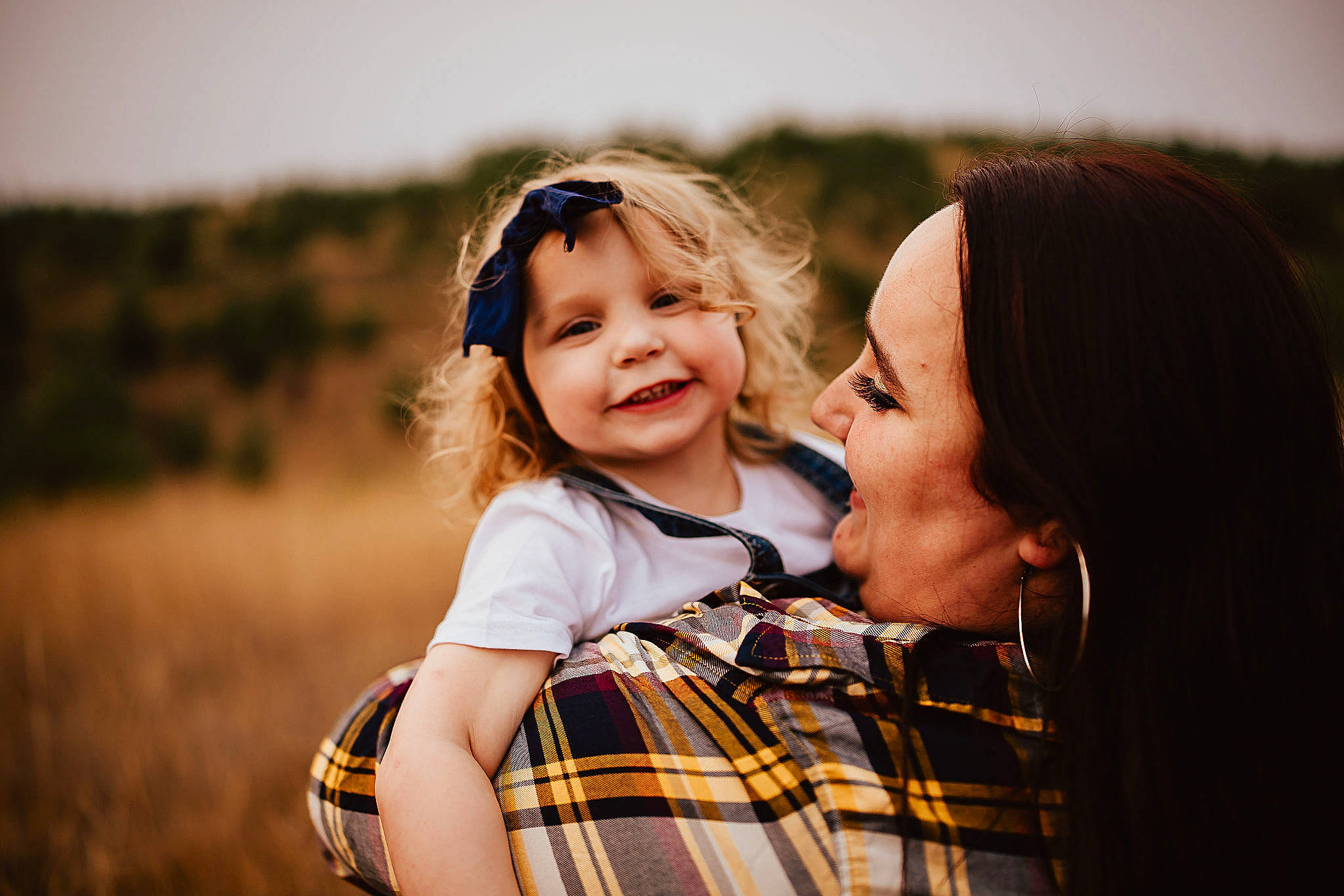 Holley is registered to the contest to win money with this photo: face, flash_photography, fun, gesture, grass, happy, headwear, interaction, iris, joy, leisure, long_hair, people_in_nature, person, plaid, plant, shoulder, sky, smile, sunlight