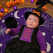 Isabella-Grace is registered to the contest to win money with this photo: baby, bat_toy, black_dress, child, costume, cute, festive, floor, halloween_costume, halloween_decorations, holiday, indoors, infant, moon_pattern, portrait, pumpkins, purple_clothing, spiderweb_pattern, stars, witch_hat
