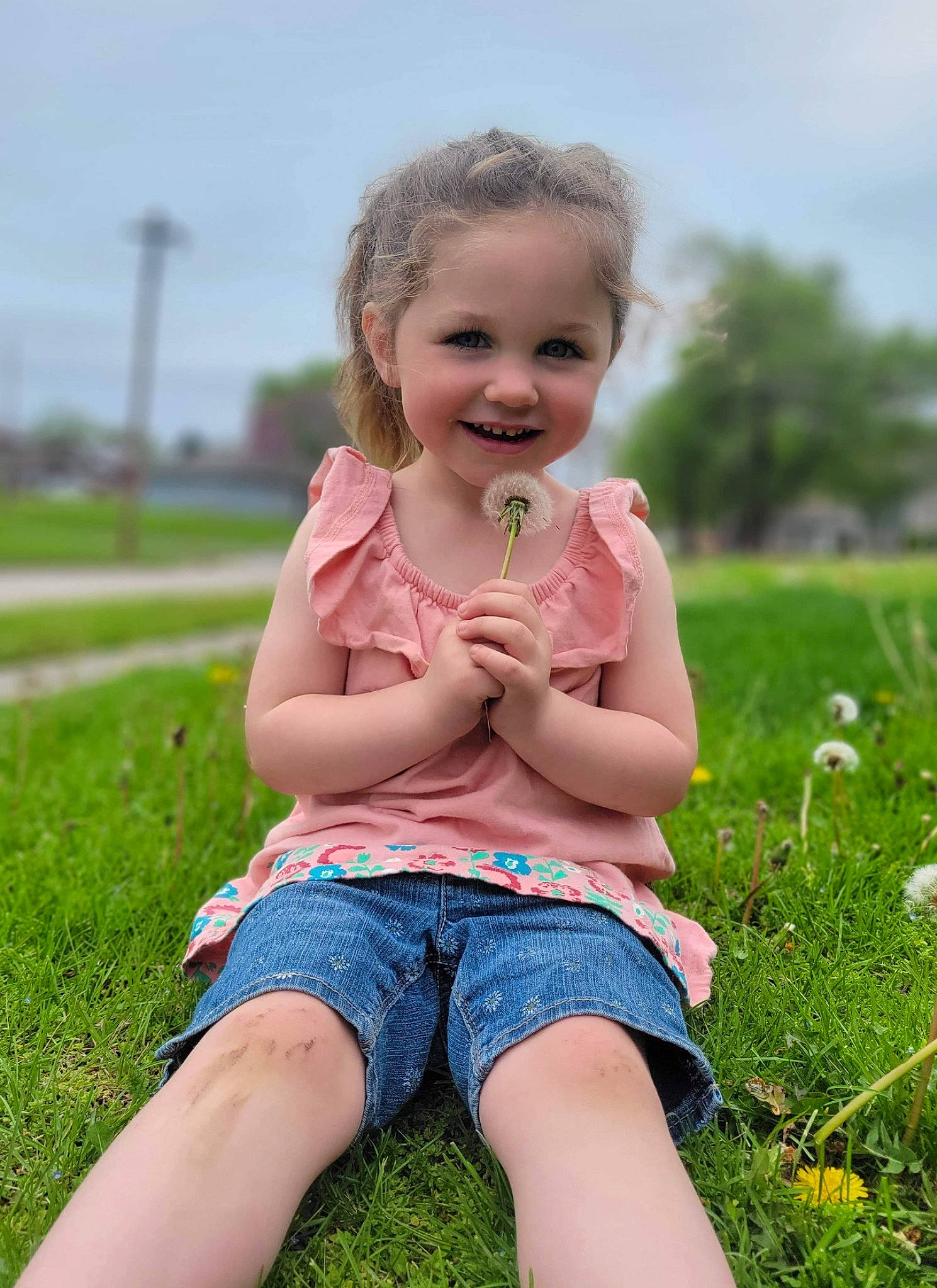 Emma is registered to the contest to win money with this photo: baby_toddler_clothing, eye, fun, grass, grass_family, grassland, hair, happy, head, iris, joy, leisure, meadow, people_in_nature, person, pink, plant, skin, sky, smile
