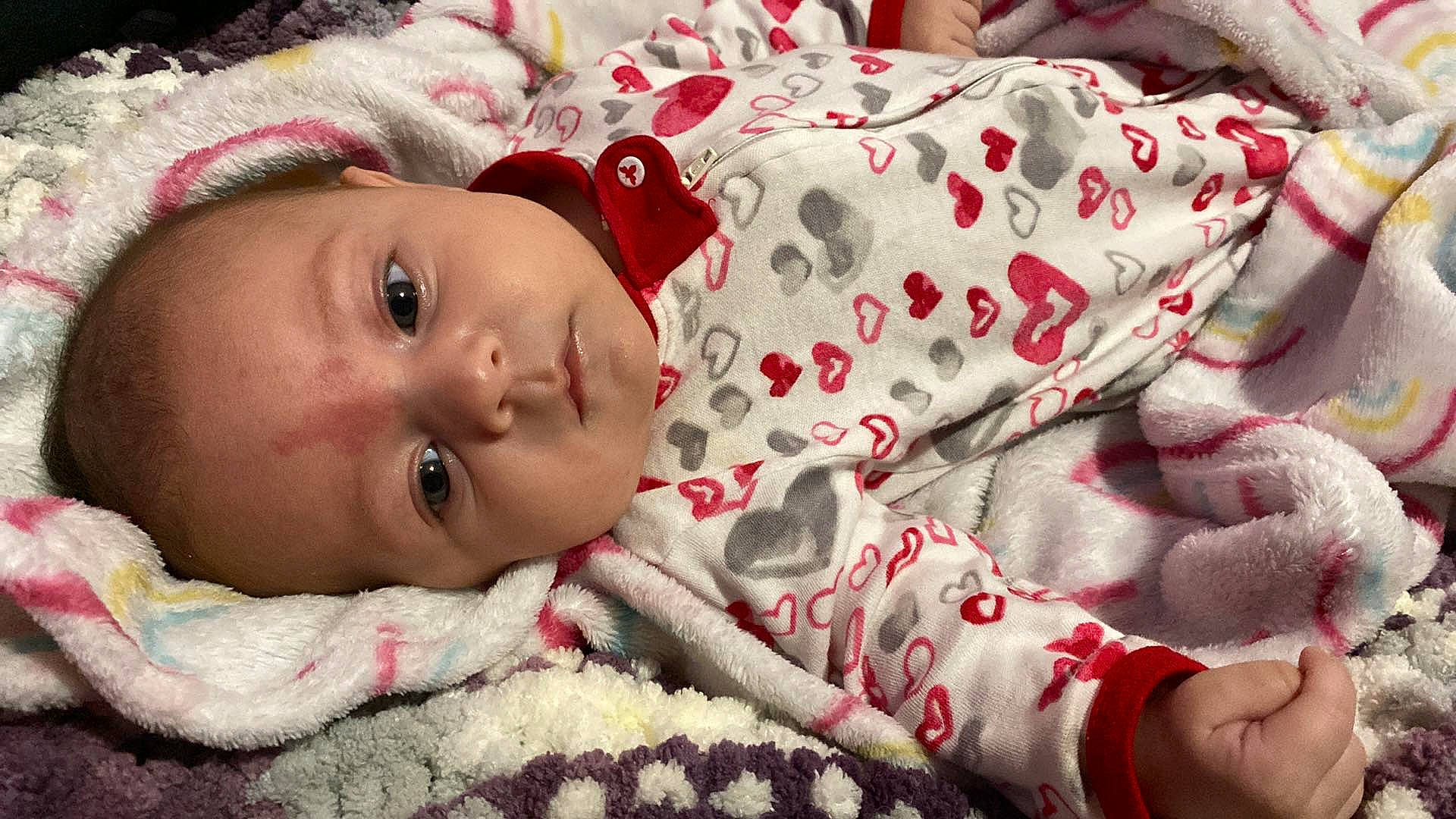 Arya joined the competition — help win amazing prizes! baby, baby_toddler_clothing, cheek, child, comfort, eye, eyelash, face, hand, happy, head, human_body, linens, lip, nose, pattern, person, red, skin, sleeve