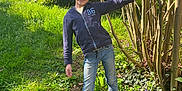 Tiago a rejoint le concours — aidez-le/la à gagner de superbes lots ! child, boy, smiling, outdoor, grass, tree, branches, jacket, jeans, sneakers, garden, greenery, sunlight, pose, portrait, nature, hedge, playful, young_person, ground