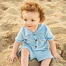 child, toddler, curly_hair, blue_outfit, sand, beach, sitting, smiling, outdoor, sunlight, cute, young_child, portrait, playful, summer, skin, face, hands, legs, nature