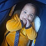 baby, child, car_seat, yellow_clothing, blue, infant, hand_in_mouth, smiling, seatbelt, cute, indoor, soft_focus, happy, person, toddler, fabric, plush, safety, seat, bright_eyes