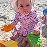 baby, child, beach, sand, toy, sun_hat, floral_clothing, sitting, play, outdoor, summer, cute, colorful, plastic_toy, sunlight, footwear_bare, infant, portrait, person, holiday