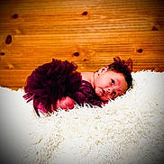 Nyla joined the competition — help win amazing prizes! baby, newborn, infant, tutu, purple_dress, headband, bow, fluffy_rug, white_rug, wood_paneling, wood_background, portrait, lying_down, posed, cute, expression, eyes_open, skin, fabric, studio_lighting