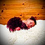 baby, newborn, infant, tutu, purple_dress, headband, bow, fluffy_rug, white_rug, wood_paneling, wood_background, portrait, lying_down, posed, cute, expression, eyes_open, skin, fabric, studio_lighting