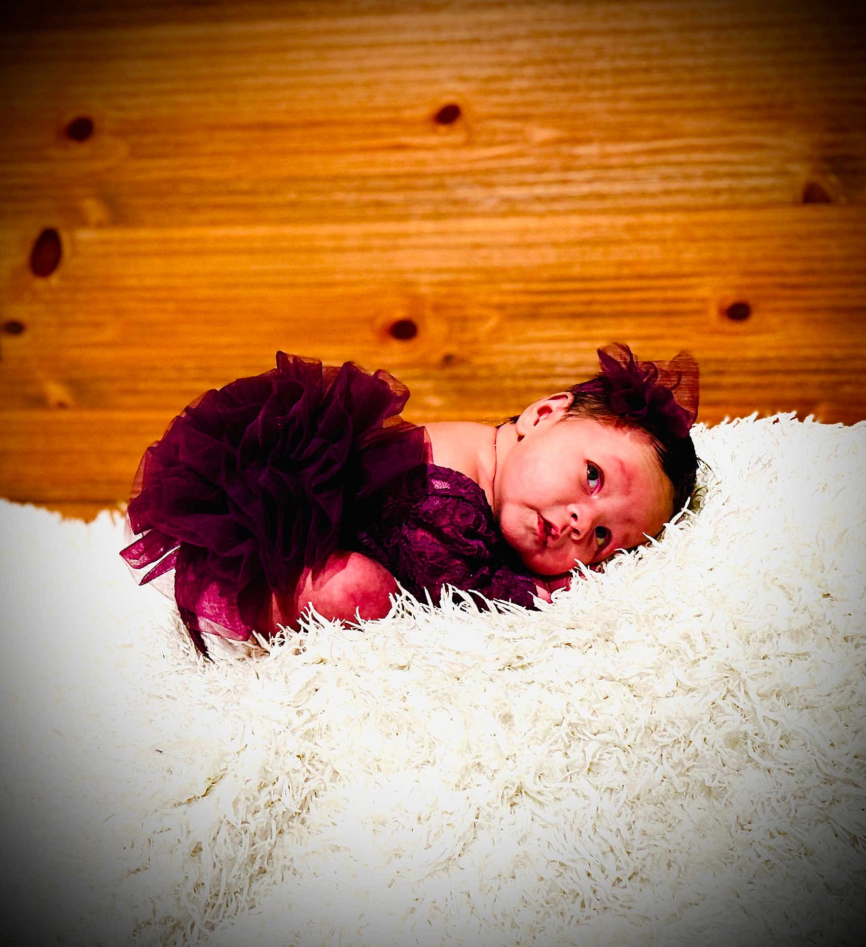 Nyla joined the competition — help win amazing prizes! baby, newborn, infant, tutu, purple_dress, headband, bow, fluffy_rug, white_rug, wood_paneling, wood_background, portrait, lying_down, posed, cute, expression, eyes_open, skin, fabric, studio_lighting