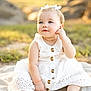 baby, child, white_dress, bow, outdoor, sunlight, blanket, sitting, cute, portrait, infant, young_child, nature, grass, face, blue_eyes, happy, soft_light, summer, youth