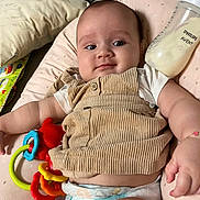 Mila a rejoint le concours — aidez-le/la à gagner de superbes lots ! baby, infant, diaper, toy, bottle, cushion, clothing, face, person, arm, hand, smile, indoor, corduroy, plastic, milk, comfortable, cute, relaxed, star_pattern