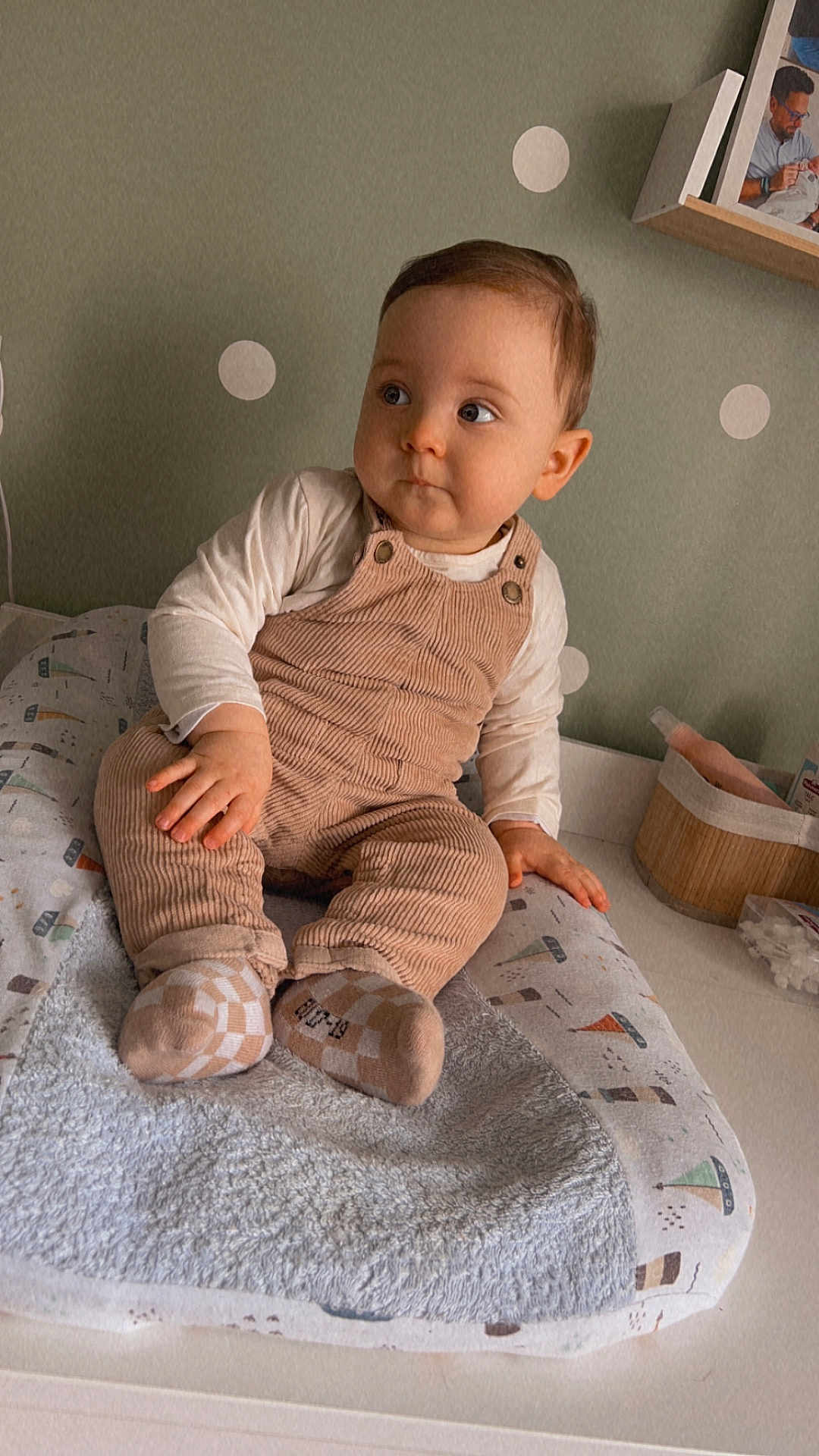 Lou participe au concours pour gagner de l'argent avec cette photo : baby, child, corduroy_overalls, socks, cushion, changing_pad, nursery, polka_dot_wall, portrait, indoor, person, infant, clothing, furniture, photography, cute, expression, seat, toddler, home
