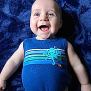 Brody Wayne is registered to the contest to win money with this photo: baby, child, smiling, blue_eyes, tank_top, octopus_print, blanket, happy, infant, cute, clothing, portrait, lying_down, skin, arms, casual_wear, indoor, one_person, young_child, toddler