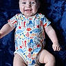 baby, blanket, blue, child, clothing, crab, cute, fish, happy, infant, lying_down, marine_life_pattern, octopus, onesie, person, portrait, seahorse, skin, smile, turtle