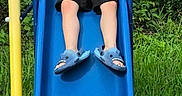 Benjamin Cash joined the competition — help win amazing prizes! child, boy, slide, playground, outdoor, grass, greenery, batman_tshirt, blue_slide, yellow_pole, smiling, shorts, footwear, shark_slippers, happy, summer, nature, fun, play, leisure