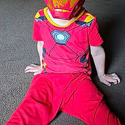Benjamin Cash is registered to the contest to win money with this photo: child, costume, iron_man, mask, red_clothing, carpet, indoor, superhero, sitting, furniture, dining_room, curious, eyes_visible, playful, home, floor, young_child, portrait, casual, bright_colors