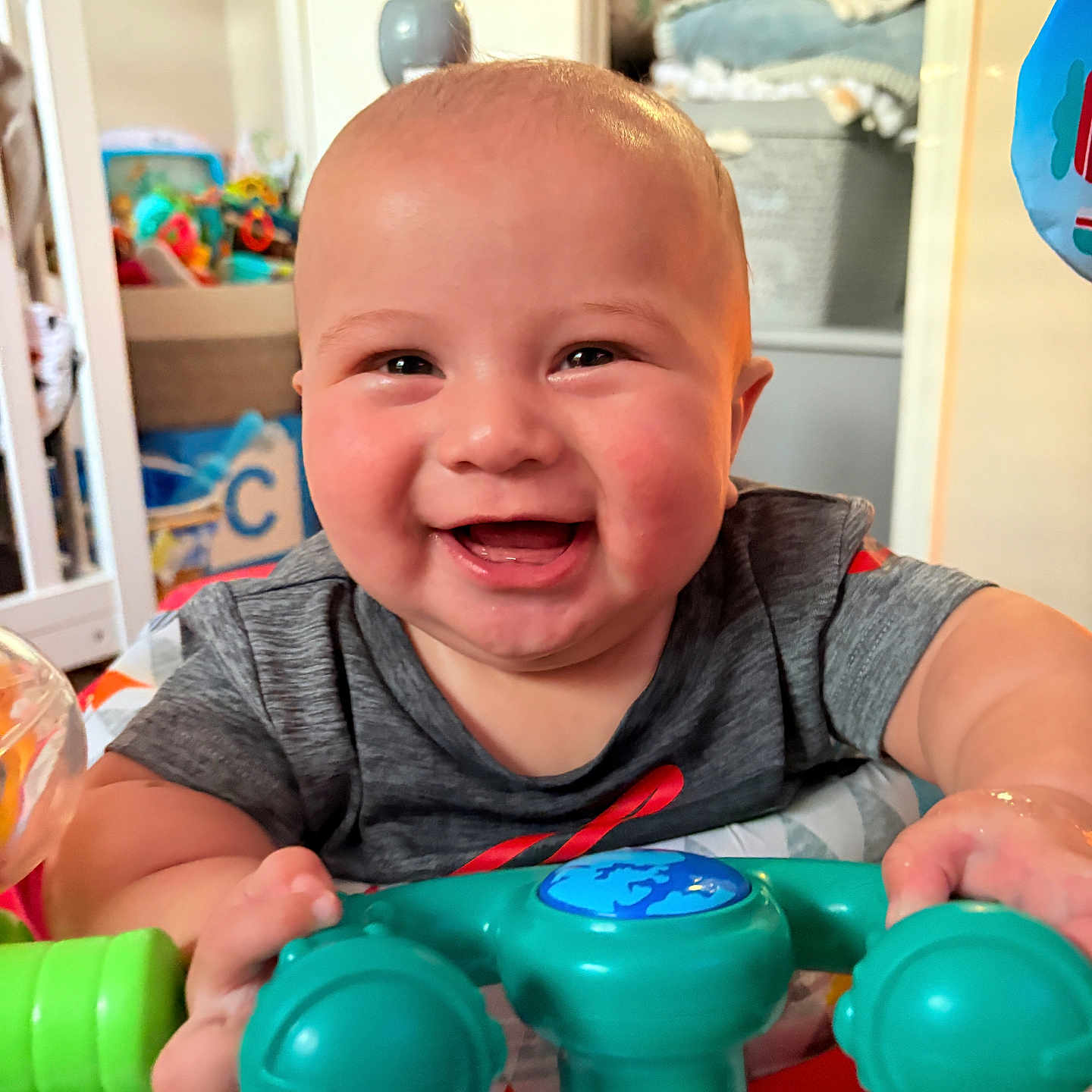 Caleb Jr. is registered to the contest to win money with this photo: architecture, baby, bodypart, building, face, finger, furniture, hand, happy, head, indoors, laughing, livingroom, person, photography, portrait, shelf, smile, sphere, toy