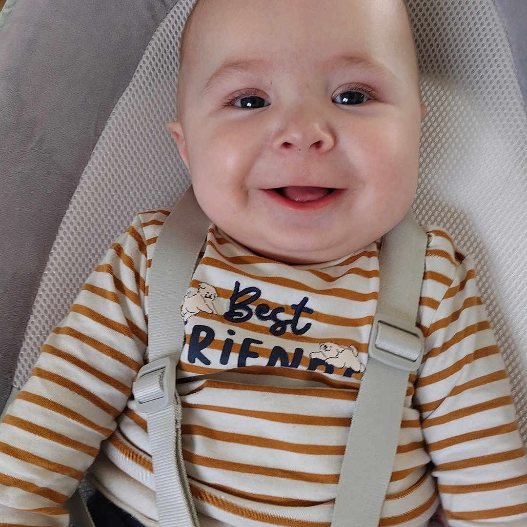 Gabriel a rejoint le concours — aidez-le/la à gagner de superbes lots ! baby, baby_seat, casual_wear, child, closeup, clothing, comfort, cute, face, hands, happy, indoor, infant, person, portrait, safety_harness, seat, smiling, striped_shirt, young_child