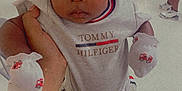 Karsyn is registered to the contest to win money with this photo: baby, background, casual, celebration, child, clothing, cute, floor, footwear, hand, indoor, infant, mittens, party_hat, people, person, portrait, sneakers, table, tommy_hilfiger