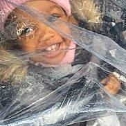 Melyana participe au concours pour gagner de l'argent avec cette photo : child, smile, face, pink_hat, winter_jacket, plastic_sheet, distortion, happy, outdoor, cold_weather, portrait, fun, wrapped, warm_clothing, cute, playful, expression, person, headwear, joy