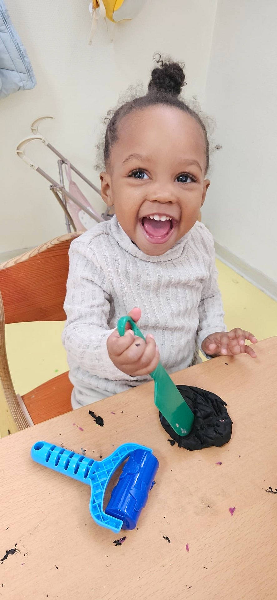 Melyana a rejoint le concours — aidez-le/la à gagner de superbes lots ! chair, child, clothing, cute, expression, face, fun, hands, happy, indoor, messy, person, plastic, playdough, playtime, smiling, table, toddler, toy, young_child