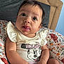 Sage joined the competition — help win amazing prizes! baby, child, infant, cute, tongue_out, sitting, mickey_mouse, shirt, clothing, floral_cushion, headboard, indoors, portrait, close_up, skin, hands, expression, happy, curious, young