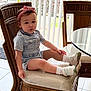 Ellie is registered to the contest to win money with this photo: toddler, child, girl, indoor, chair, cushion, headband, bow, denim, outfit, socks, shoes, glass_table, vertical_blinds, wooden_furniture, calm, contemplative, home, greenery, natural_light