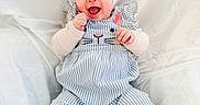 Riya is registered to the contest to win money with this photo: baby, smiling, child, infant, headband, white_bow, striped_clothing, bunny_design, sitting, happy, cute, portrait, soft_background, indoors, fingers, barefoot, light_skin, clothing, baby_clothes, expression