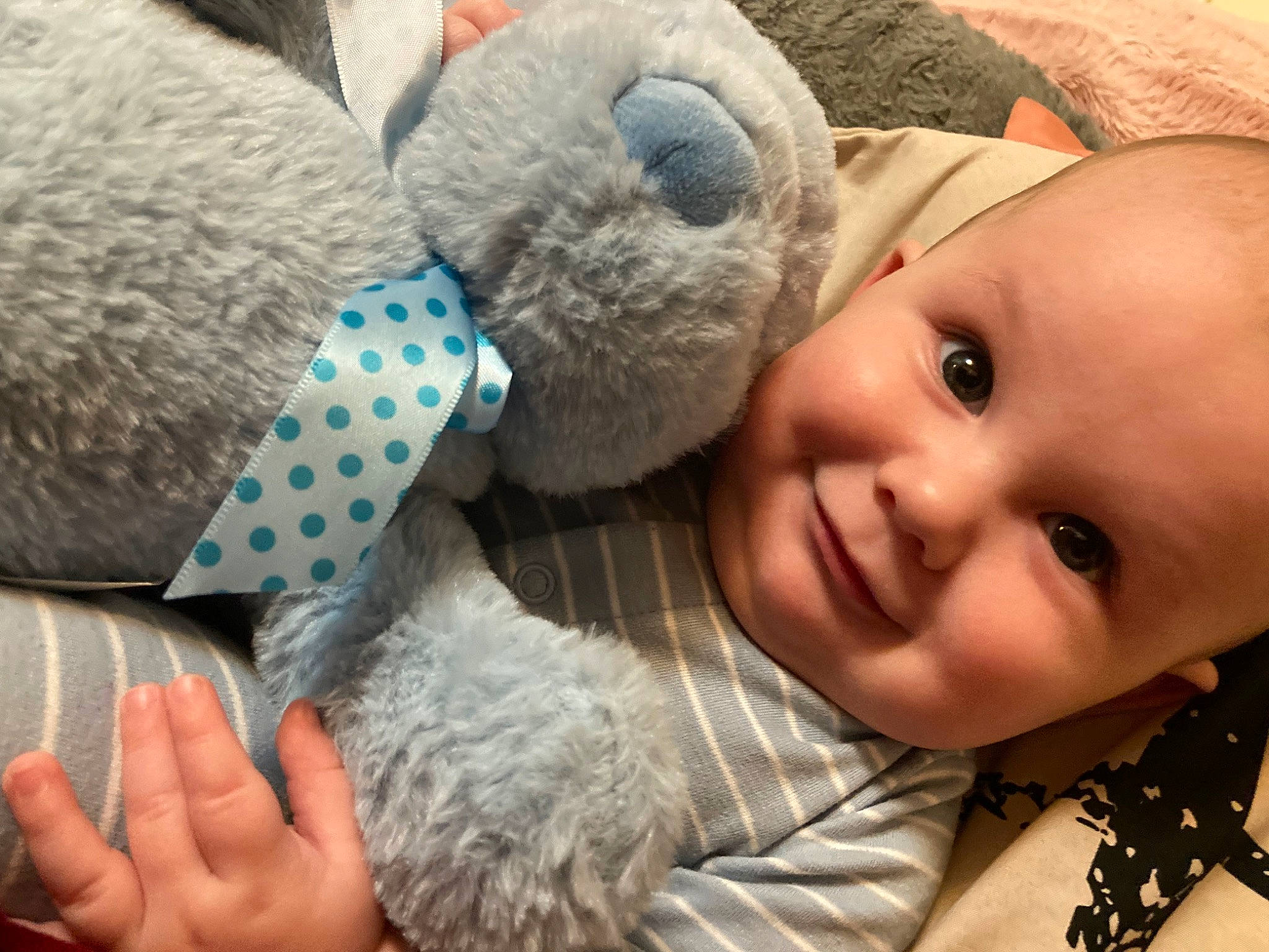 Kaius is registered to the contest to win money with this photo: baby, baby_toddler_clothing, child, comfort, couch, fashion_accessory, gesture, happy, joy, mammal, nose, pattern, person, product, skin, smile, stuffed_toy, textile, toddler, toy