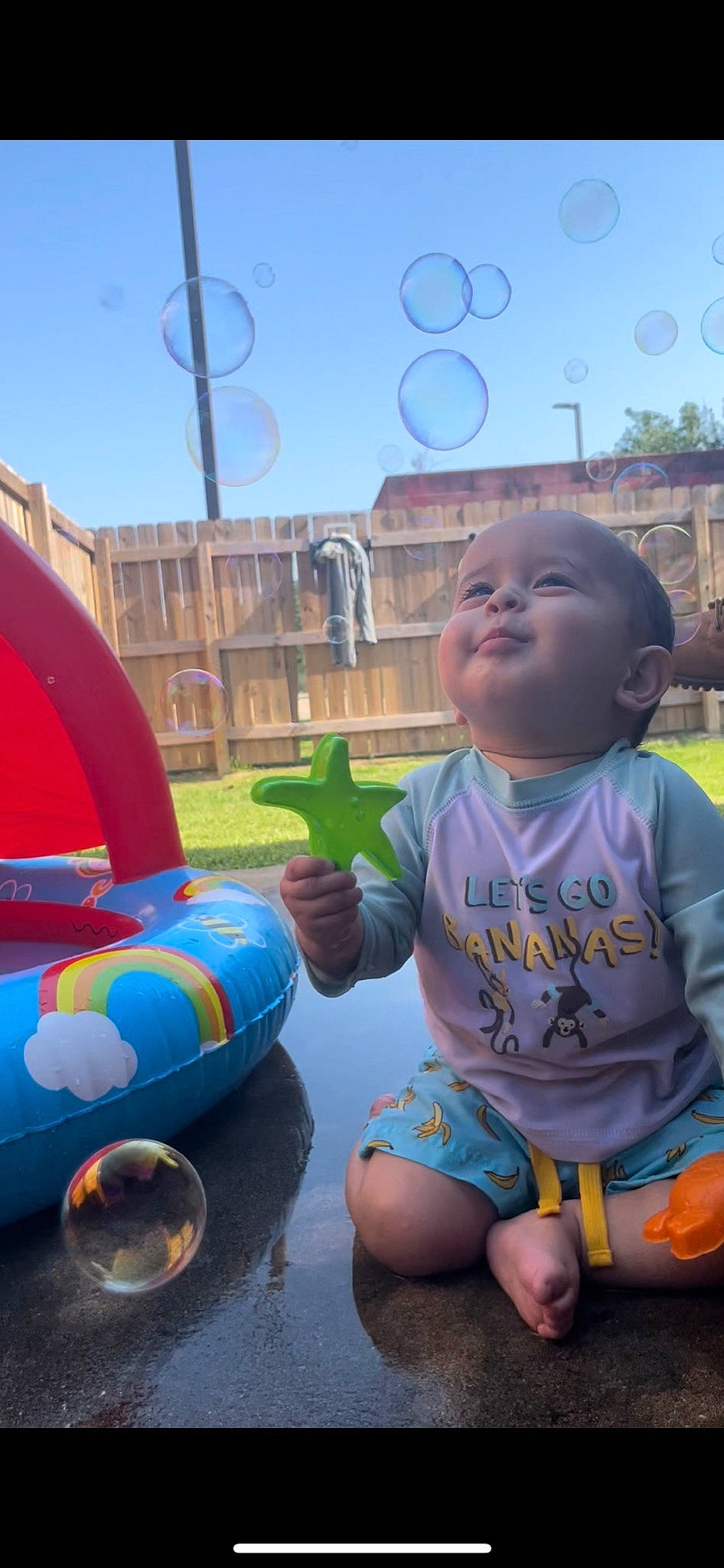 Adonai is registered to the contest to win money with this photo: azure, baby, baby_toddler_clothing, child, city, fun, grass, happy, inflatable, leisure, light, nonbuilding_structure, person, play, recreation, sitting, sky, summer, toddler, vacation