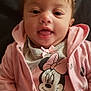 River is registered to the contest to win money with this photo: baby, child, smiling, pink_jacket, minnie_mouse, cartoon, hand, holding, portrait, happy, cute, infant, clothing, face, person, indoor, young_child, cute_expression, sitting, toddler