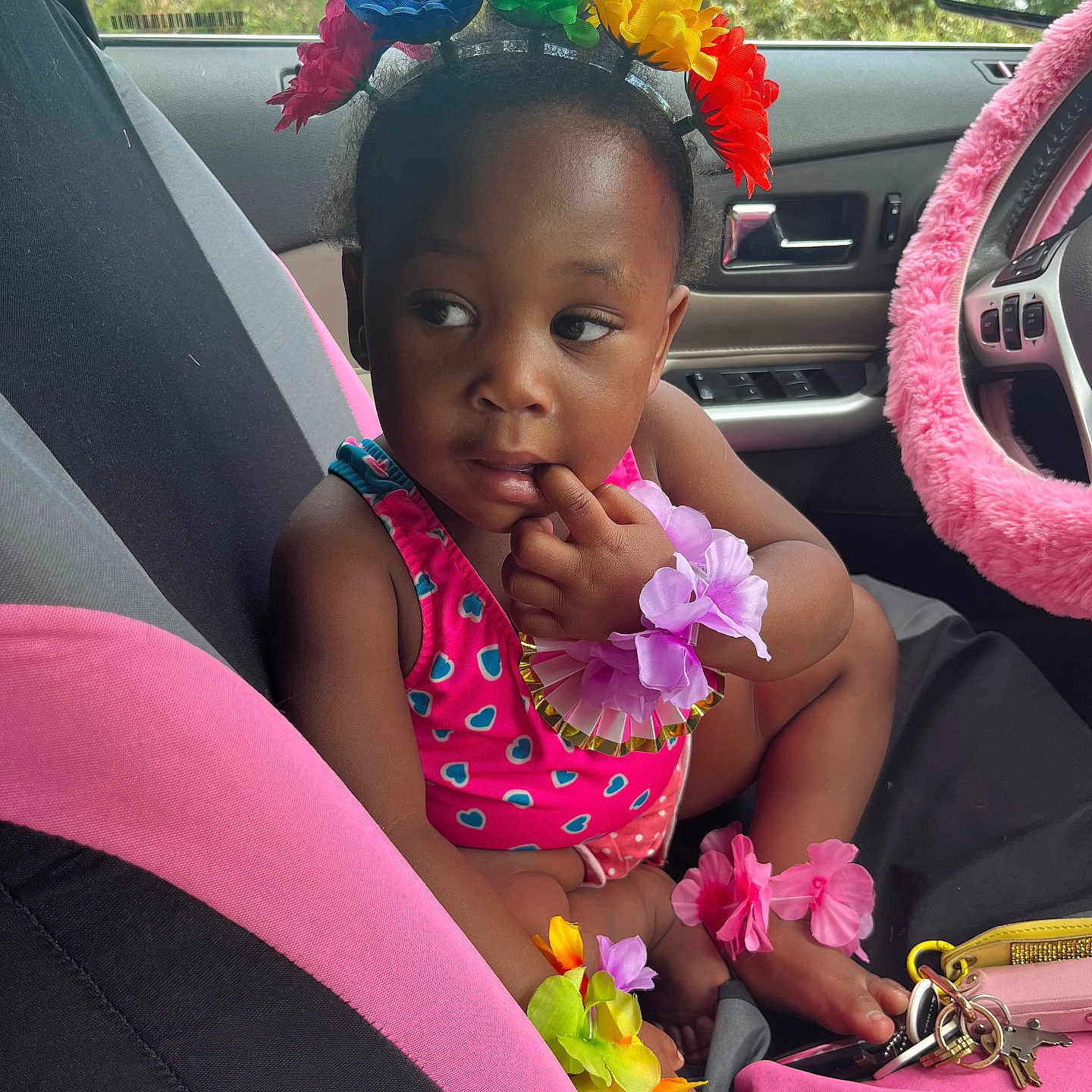 Nicole is registered to the contest to win money with this photo: toddler, child, car_seat, flower_headband, pink, colorful, bracelets, car_interior, steering_wheel, keys, thoughtful, cute, baby, seat_cover, accessories, hand, foot, summer_clothing, window, nature_background