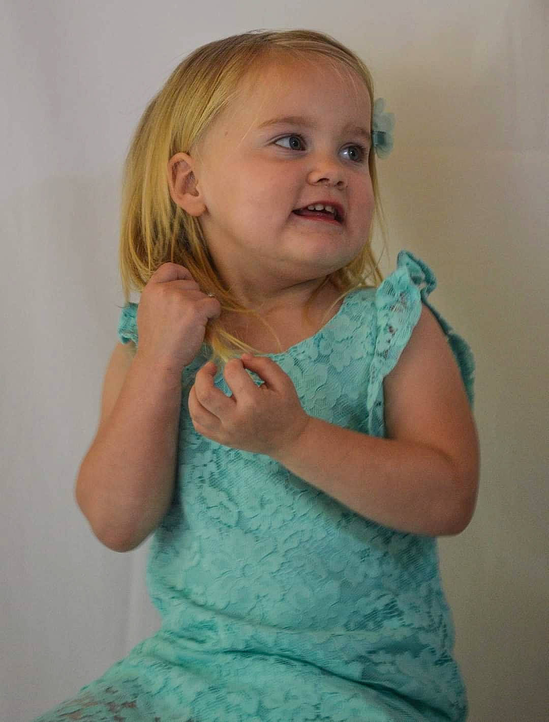 Baylee is registered to the contest to win money with this photo: arm, baby_toddler_clothing, cheek, dress, elbow, finger, gesture, hair, hairstyle, hand, happy, head, human_body, joint, neck, person, pink, shoulder, skin, sleeve