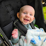 Atreus is registered to the contest to win money with this photo: baby, child, infant, smiling, happy, stroller, blanket, portrait, outdoor, close_up, face, blue_eyes, laughing, seated, carriage, clothing, hand, baby_gear, soft_blanket, candid