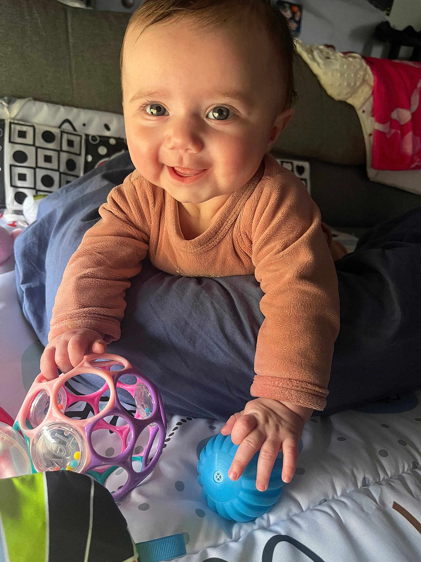 Ilyana participe au concours pour gagner de l'argent avec cette photo : baby, child, toy, smiling, indoor, face, hand, play, colorful, cushion, blanket, pattern, infant, happy, toddler, clothing, person, closeup, cute, expression