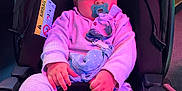Mylann a rejoint le concours — aidez-le/la à gagner de superbes lots ! baby, pacifier, car_seat, child, infant, clothing, pink_lighting, purple_lighting, indoor, seatbelt, soft_toys, cute, person, young_child, face, hand, sitting, cozy, warm_clothing, car_accessory
