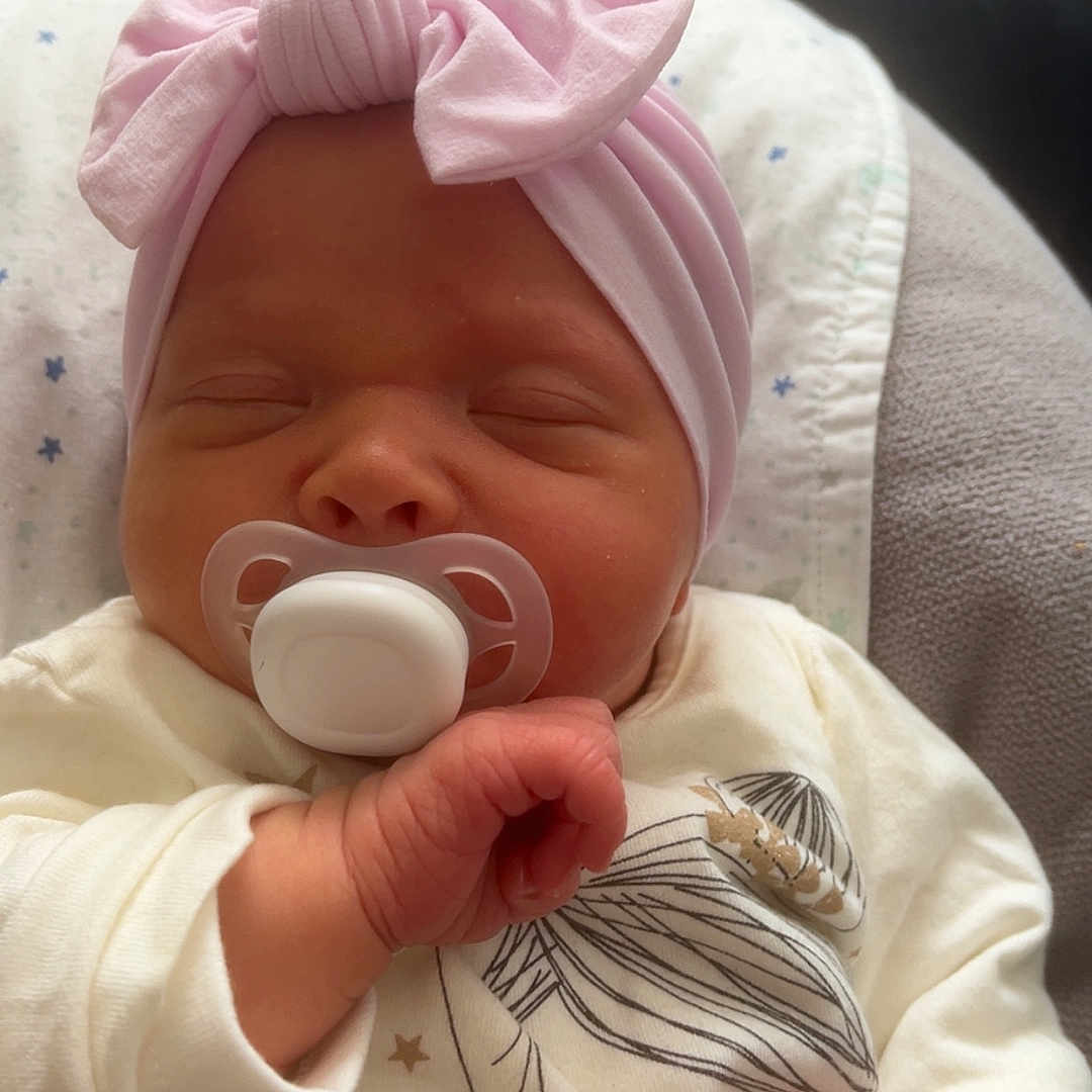 Solea participe au concours pour gagner de l'argent avec cette photo : apparel, baby, child, cozy, cushion, cute, face, hand, headband, illustration, indoors, infant, newborn, onesie, pacifier, peaceful, pink_bow, portrait, sleeping, soft