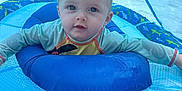 Mateo is registered to the contest to win money with this photo: baby, blue, child, curly_hair, cute, face, float, fun, inflatable, outdoor, people, person, play, pool, recreation, splash, summer, sunshade, swimming, water