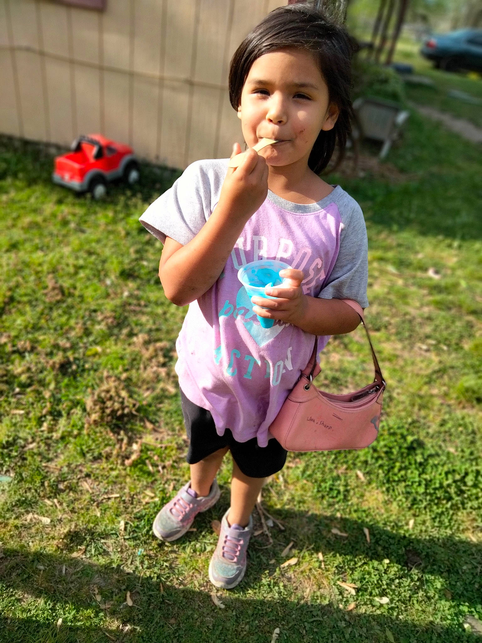 Ketaeyah is registered to the contest to win money with this photo: boot, child, fun, grass, grassland, green, happy, leisure, magenta, people_in_nature, person, pink, plant, recreation, sandal, shorts, sitting, smile, soil, t_shirt