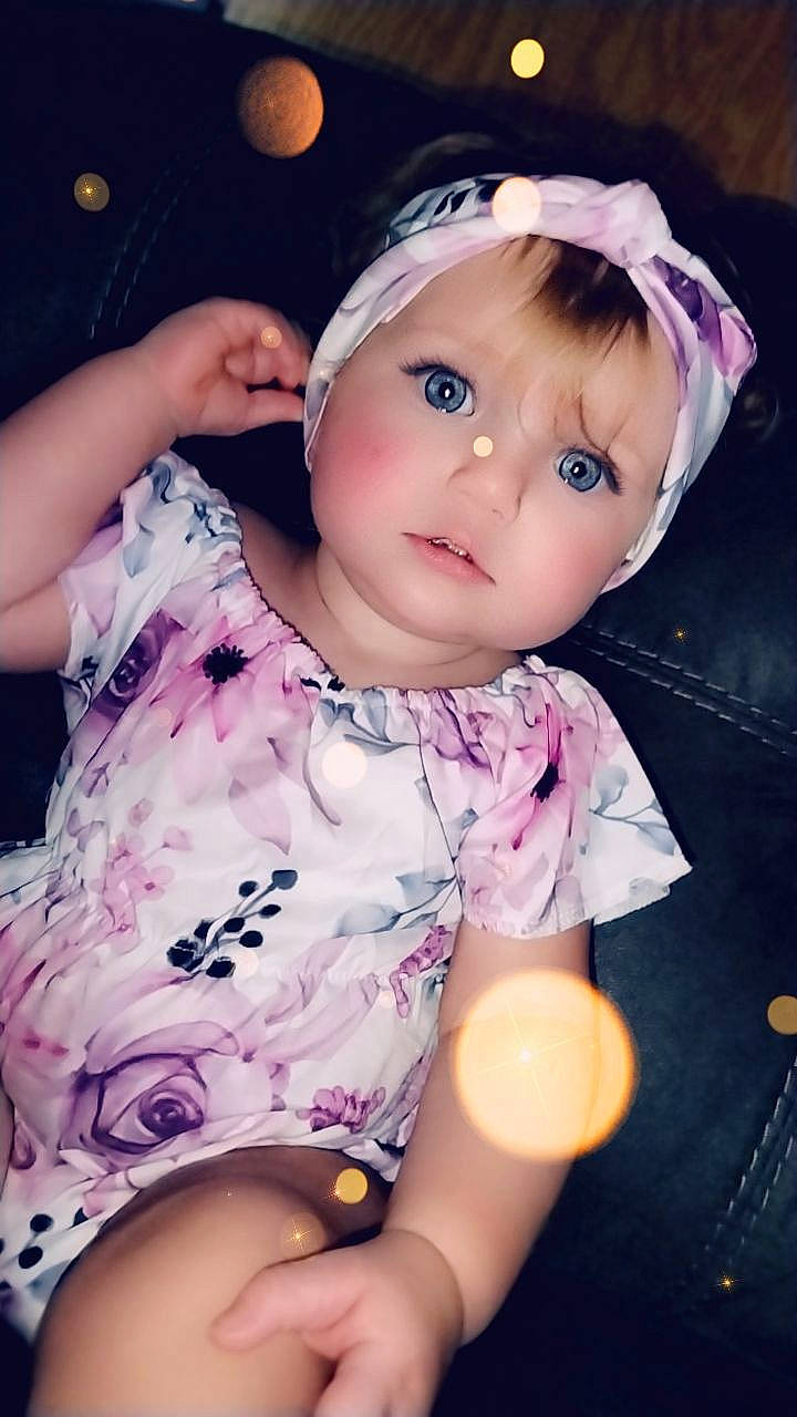 Zailynn is registered to the contest to win money with this photo: baby, baby_toddler_clothing, brown_hair, cheek, child, dress, eyelash, flash_photography, headgear, iris, lip, magenta, nose, pattern, person, pink, purple, skin, sleeve, thigh