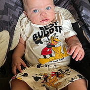 Rhayne joined the competition — help win amazing prizes! baby, blue_eyes, cartoon, child, clothing, cute, expression, fabric, foot, hand, indoor, infant, mickey_mouse, person, pluto, portrait, shorts, sitting, stroller, tshirt