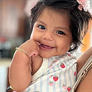 Karelyn joined the competition — help win amazing prizes! baby, child, smiling, cute, girl, flower, hair_accessory, bracelet, strawberry_pattern, pink_skirt, hand, portrait, happy, person, indoor, closeup, infant, playful, dimple, holding