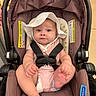 baby, infant, car_seat, hat, white_hat, straps, sitting, indoor, child, cute, pink_clothing, foot, hand, face, expression, seat, safety, person, young_child, adorable