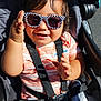 toddler, child, sunglasses, stroller, smiling, sunlight, happy, baby, seatbelt, casual_clothing, striped_shirt, outdoor, person, young_child, cute, fashion, hands, portrait, playful, shiny_hair