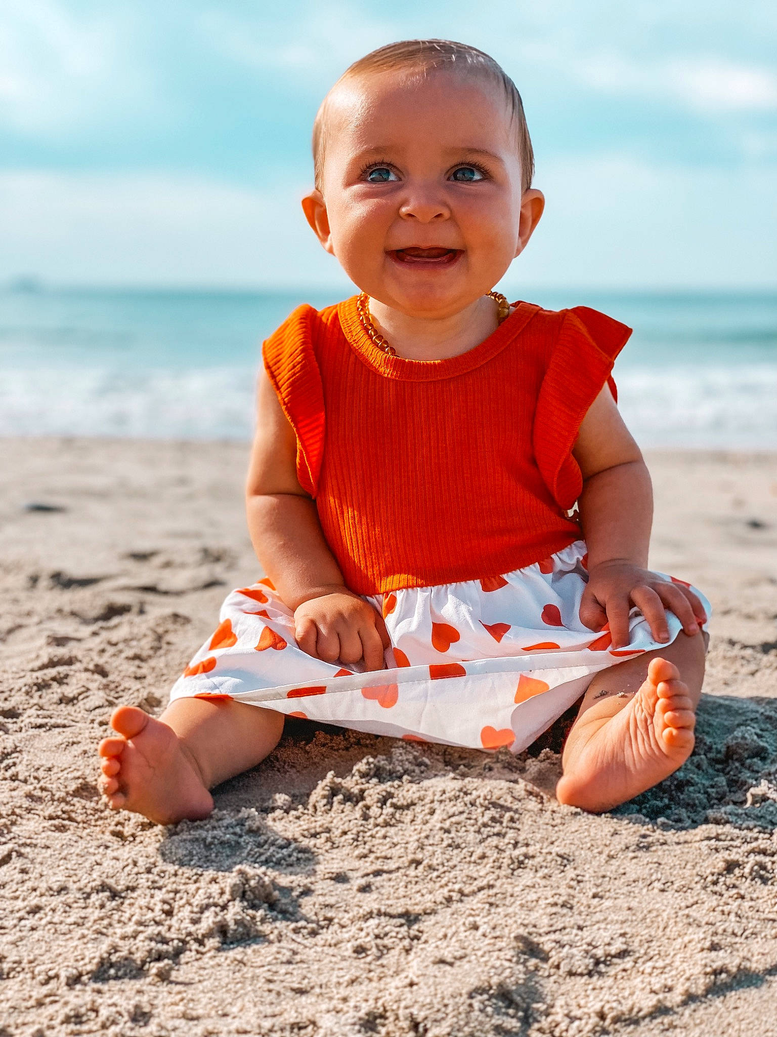 Hilyana a rejoint le concours — aidez-le/la à gagner de superbes lots ! baby_toddler_clothing, beach, child, cloud, dress, fun, happy, joy, orange, people_in_nature, people_on_beach, person, sand, sitting, sky, sleeve, smile, sunlight, t_shirt, toddler