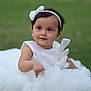 baby, child, girl, dress, white_dress, headband, bow, outdoor, grass, cute, smile, portrait, young_child, sitting, innocent, fashion, sparkle, happy, person, soft