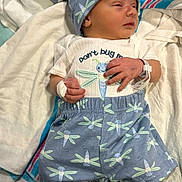 Waylan is registered to the contest to win money with this photo: newborn, baby, infant, clothing, hat, blanket, hospital, wristband, bandage, dragonfly, pattern, sleeping, lying_down, cute, child, person, soft, comfort, small, portrait
