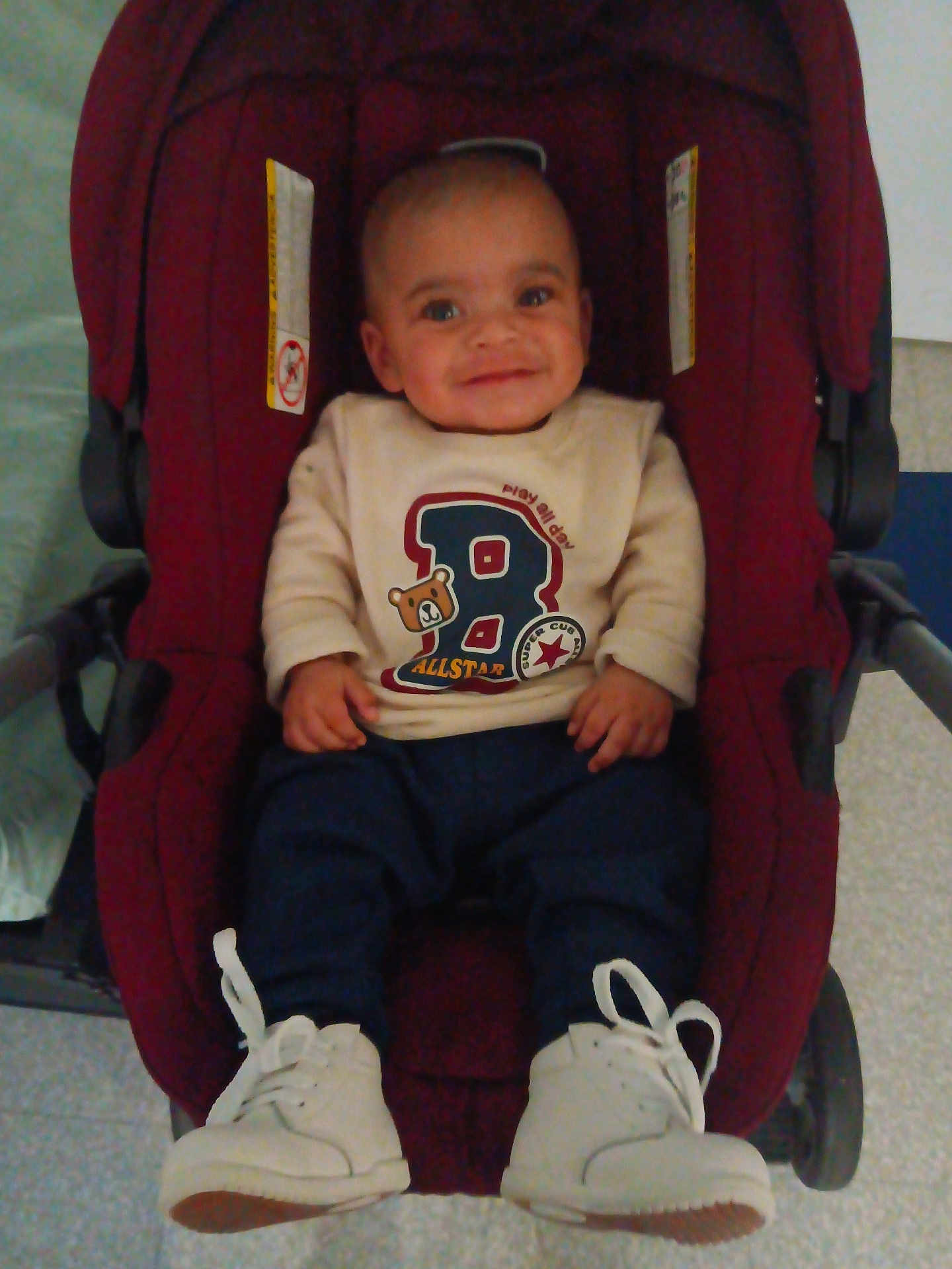 Noah Joseph joined the competition — help win amazing prizes! baby, child, smile, stroller, sweater, pants, shoes, white_shoes, indoor, cute, infant, person, happy, face, seated, clothing, footwear, baby_boy, casual, playful