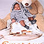 Emersyn joined the competition — help win amazing prizes! baby, teddy_bear, blanket, gray_robe, diaper, socks, soft_toy, plush, child, cute, portrait, indoor, comfort, infant, resting, warm, cozy, smiling, cuddly, relaxed