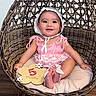 baby, child, infant, smiling, pink_clothing, bonnet, rattan_chair, woven_chair, cushion, wooden_floor, milestone_sign, 5_months, flower_sign, cute, sitting, indoors, portrait, happy, person, young_child