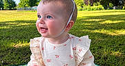 Luna is registered to the contest to win money with this photo: baby, crown, outdoor, grass, smiling, sunlight, blue_eyes, dress, blanket, nature, park, child, sitting, happy, infant, greenery, cute, portrait, daylight, young